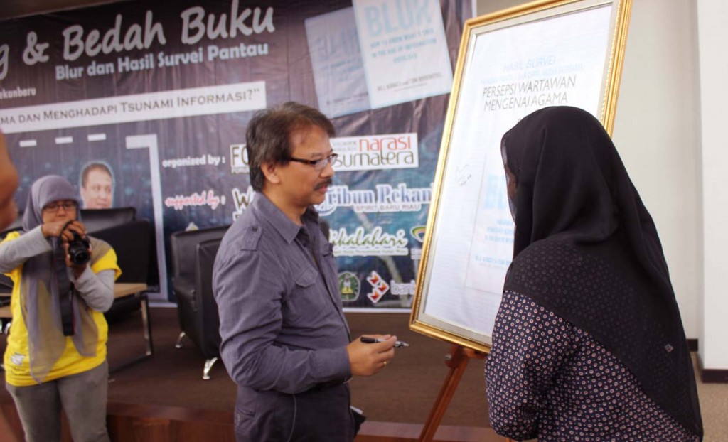 Endy Bayuni tanda tangan cover saat launching Buku Blur dan Hasil Survei Yayasan Pantau