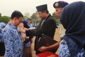 Rektor menyematkan lencana dan beri piagam penghargaan Satyalancana Karya Satya kepada para perwakilan dosen.